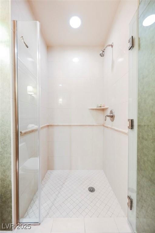 full bath with tile patterned floors and a shower stall