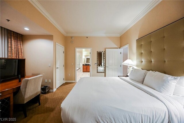 bedroom featuring hardwood / wood-style floors, ensuite bathroom, baseboards, and ornamental molding