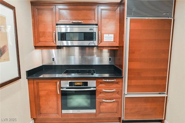 kitchen featuring dark countertops, brown cabinets, and stainless steel appliances