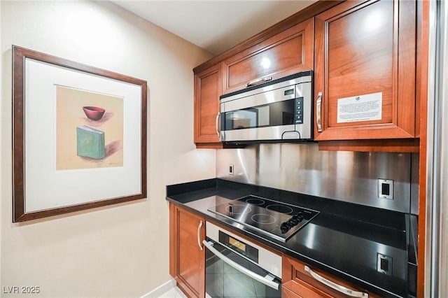 kitchen featuring dark countertops, brown cabinetry, and appliances with stainless steel finishes