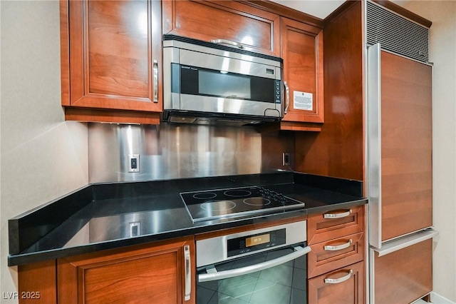 kitchen with dark countertops, brown cabinets, and stainless steel appliances