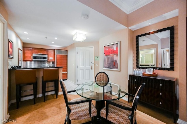 dining room with recessed lighting, crown molding, and baseboards