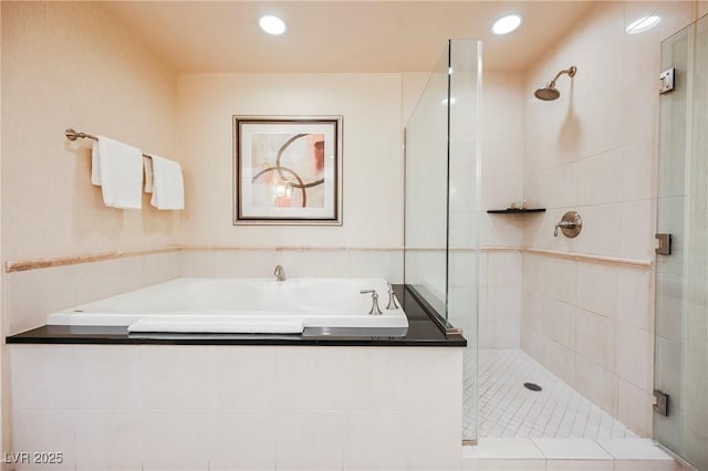 full bath featuring recessed lighting, a garden tub, and a shower stall