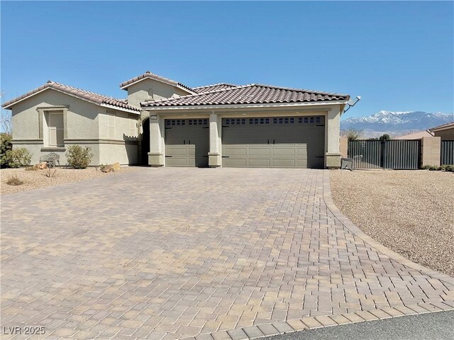 view of front of house featuring a tile roof, decorative driveway, an attached garage, and stucco siding