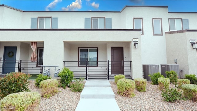 view of property featuring central AC unit, stucco siding, and a porch