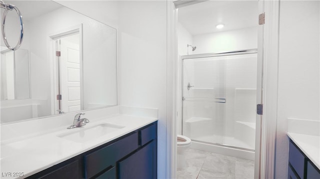 bathroom featuring a stall shower, vanity, toilet, and marble finish floor