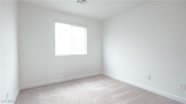 spare room featuring carpet flooring, visible vents, and baseboards