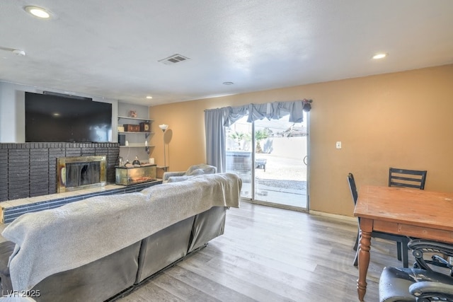 2450 Tournament St, Las Vegas, NV 89142 - living room featuring light wood-type flooring, visible vents, a brick fireplace, and recessed lighting