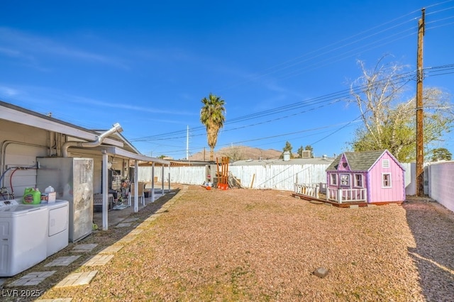 2450 Tournament St, Las Vegas, NV 89142 - view of yard with an outbuilding, independent washer and dryer, a fenced backyard, a storage shed, and a patio area