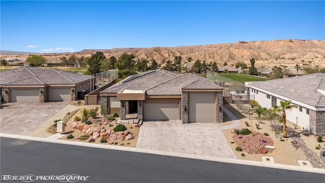 view of front facade featuring stone siding, stucco siding, concrete driveway, and a garage