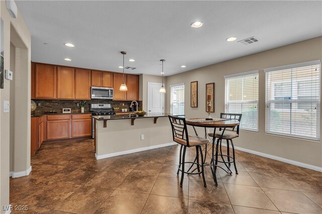 2376 Via Firenze, Henderson, NV 89044 - kitchen with stainless steel appliances, dark countertops, recessed lighting, backsplash, and baseboards