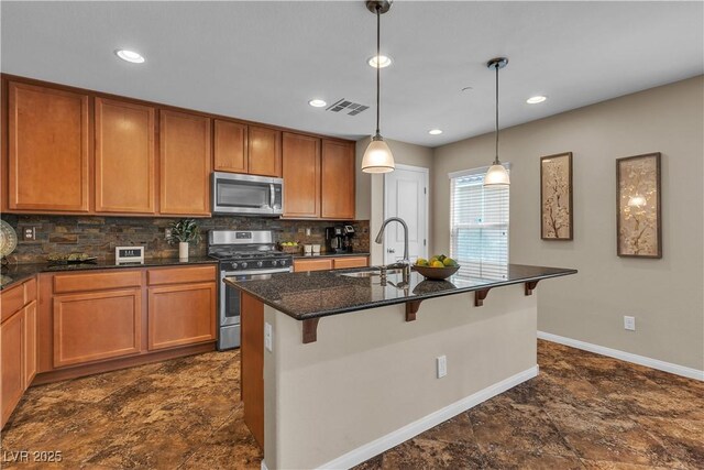 2376 Via Firenze, Henderson, NV 89044 - kitchen with stainless steel appliances, a sink, baseboards, tasteful backsplash, and brown cabinets