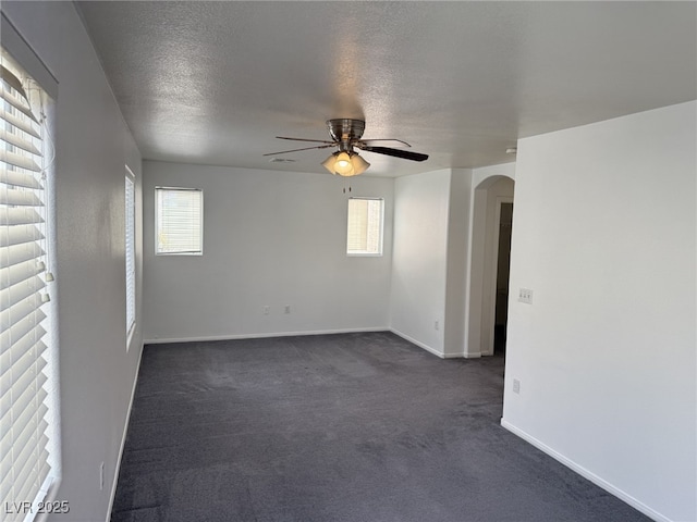 5661 Bonds Flat St, Las Vegas, NV 89148 - unfurnished room featuring ceiling fan, arched walkways, plenty of natural light, dark colored carpet, and a textured ceiling