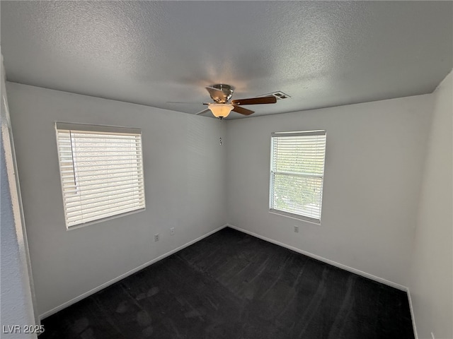 5661 Bonds Flat St, Las Vegas, NV 89148 - empty room featuring a ceiling fan, a textured ceiling, dark colored carpet, and baseboards