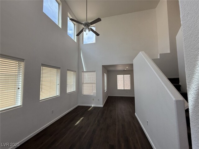 5661 Bonds Flat St, Las Vegas, NV 89148 - unfurnished living room featuring a towering ceiling, wood finished floors, plenty of natural light, a ceiling fan, and baseboards