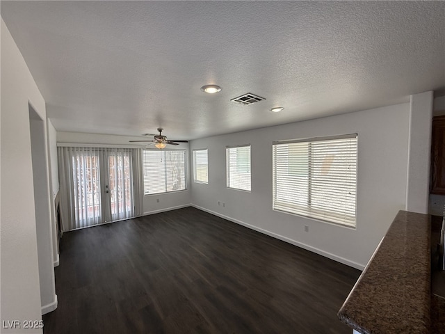 5661 Bonds Flat St, Las Vegas, NV 89148 - unfurnished living room with dark wood-type flooring, baseboards, ceiling fan, and a textured ceiling