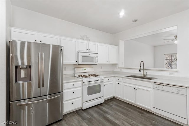 kitchen featuring white appliances, white cabinetry, light countertops, and a sink