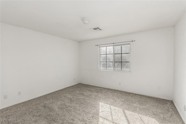 carpeted spare room featuring visible vents