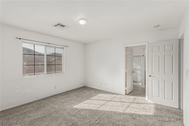 carpeted empty room featuring visible vents