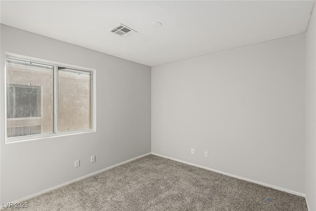 carpeted spare room with visible vents and baseboards