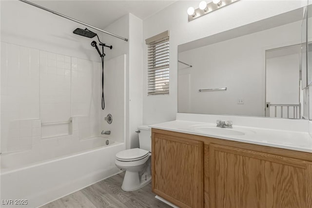 full bathroom with washtub / shower combination, toilet, wood finished floors, and vanity