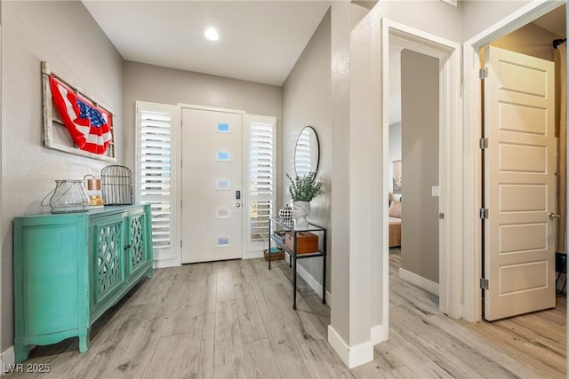 foyer featuring light wood finished floors and baseboards