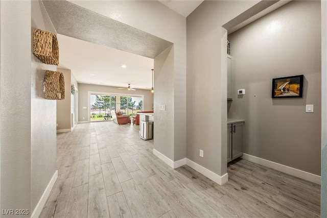 hallway with baseboards and light wood-type flooring