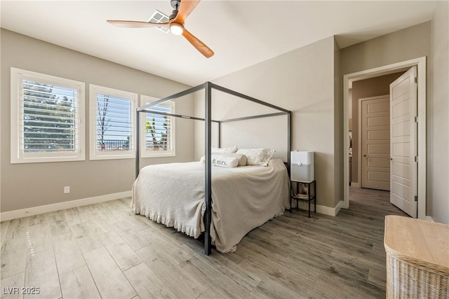 bedroom with ceiling fan, visible vents, baseboards, and wood finished floors