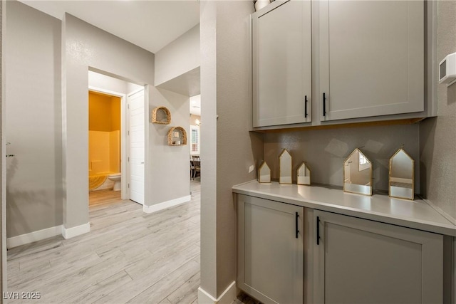 bar featuring light wood finished floors and baseboards