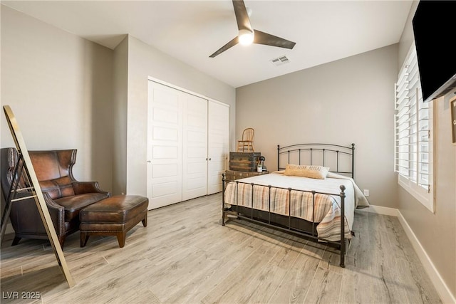 bedroom with visible vents, baseboards, a closet, a ceiling fan, and light wood finished floors
