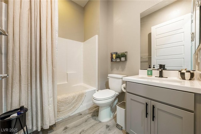 full bathroom featuring toilet, vanity, wood finished floors, and shower / bath combination with curtain