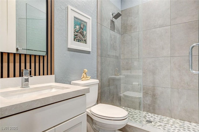 full bath featuring toilet, vanity, and a stall shower