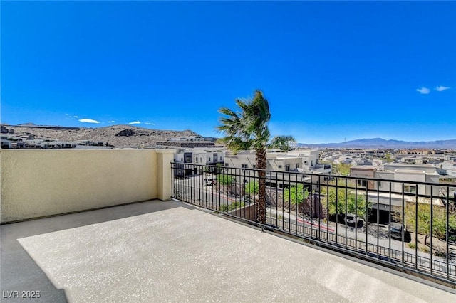 view of patio / terrace featuring a balcony, a residential view, and a mountain view