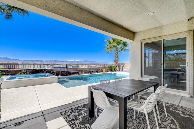 view of swimming pool with fence, a fenced in pool, outdoor dining area, a mountain view, and a patio area
