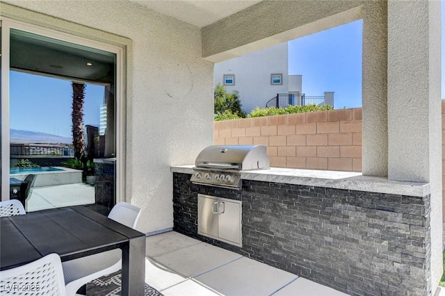 view of patio / terrace with outdoor dining area, an outdoor kitchen, and area for grilling