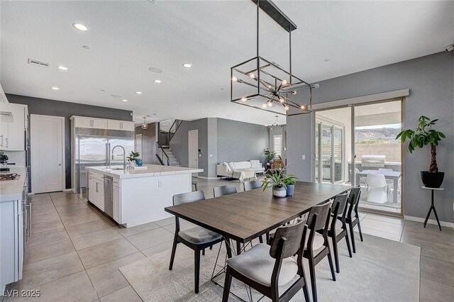 dining area with light tile patterned flooring, visible vents, recessed lighting, stairway, and a notable chandelier