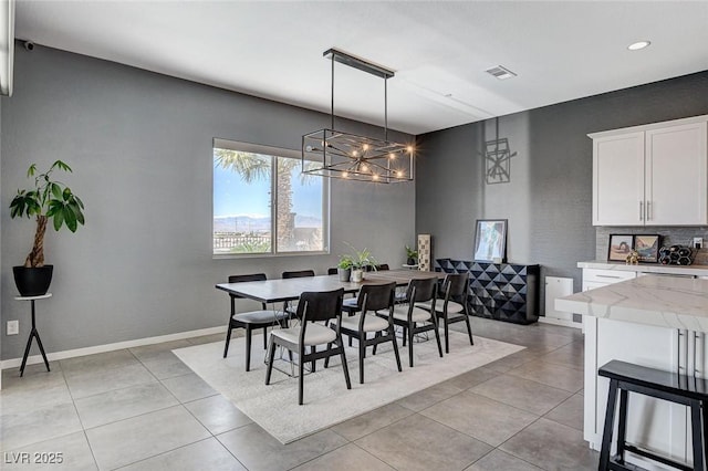 dining room featuring an inviting chandelier, light tile patterned flooring, baseboards, and visible vents
