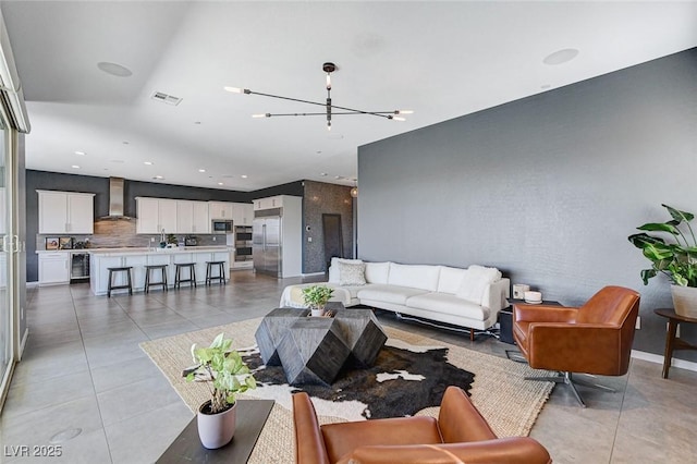 living room featuring light tile patterned flooring, visible vents, an inviting chandelier, and recessed lighting