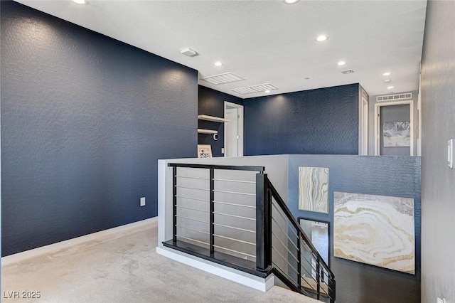 interior space with carpet flooring, visible vents, a textured wall, and recessed lighting