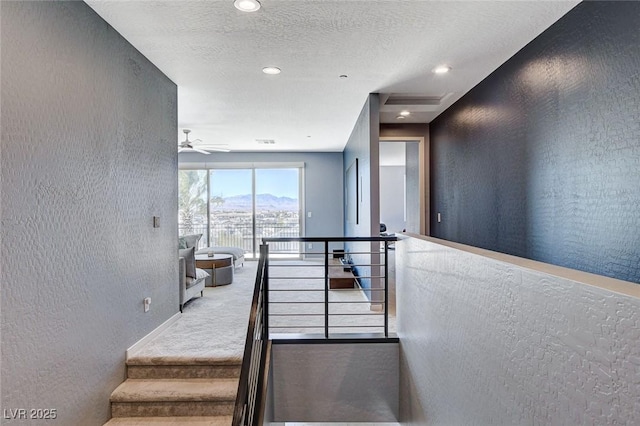 staircase with recessed lighting, carpet flooring, a textured wall, a textured ceiling, and ceiling fan