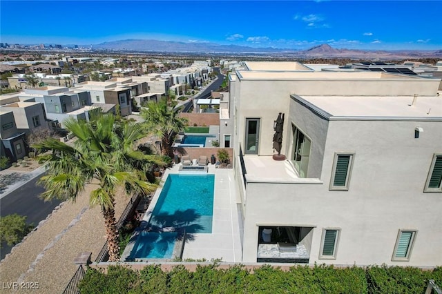 view of swimming pool featuring a mountain view, a pool with connected hot tub, and a patio area