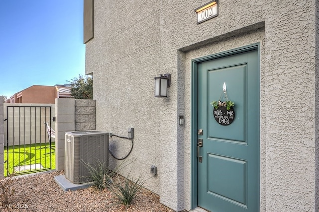 property entrance with central air condition unit and stucco siding