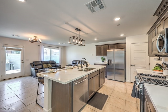 kitchen with visible vents, open floor plan, light tile patterned floors, stainless steel appliances, and a sink