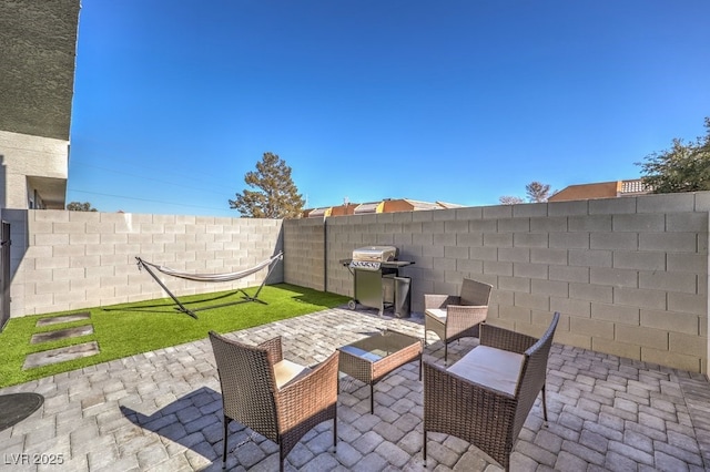 view of patio with grilling area and a fenced backyard