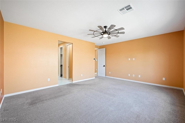 carpeted spare room featuring visible vents, baseboards, and ceiling fan
