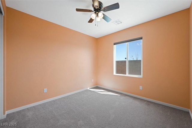 carpeted spare room featuring baseboards, ceiling fan, and visible vents