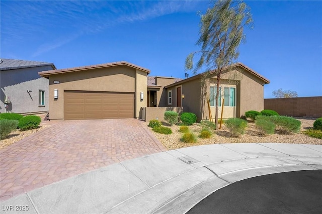 view of front of house with a garage, fence, stucco siding, and driveway