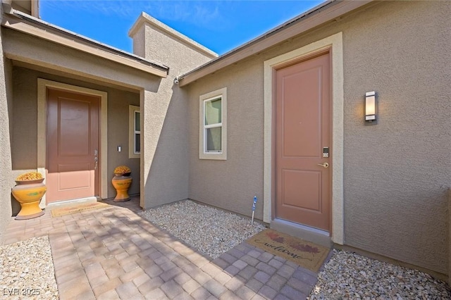 doorway to property featuring a patio area and stucco siding