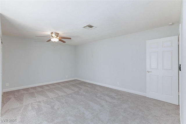 empty room with baseboards, ceiling fan, light colored carpet, and visible vents