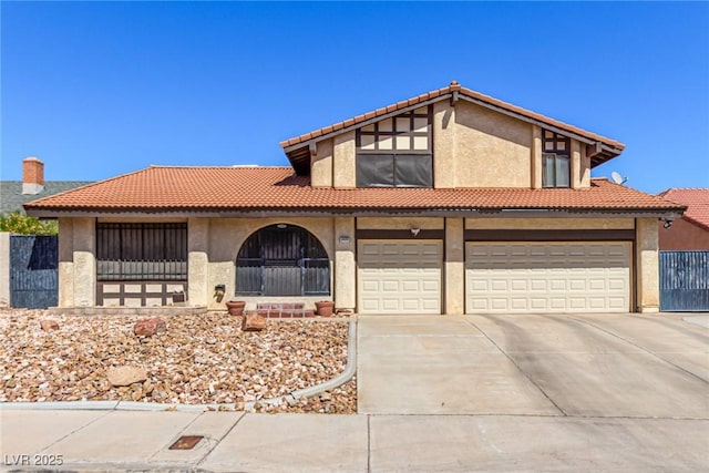 view of front facade with concrete driveway, a garage, a tile roof, and stucco siding